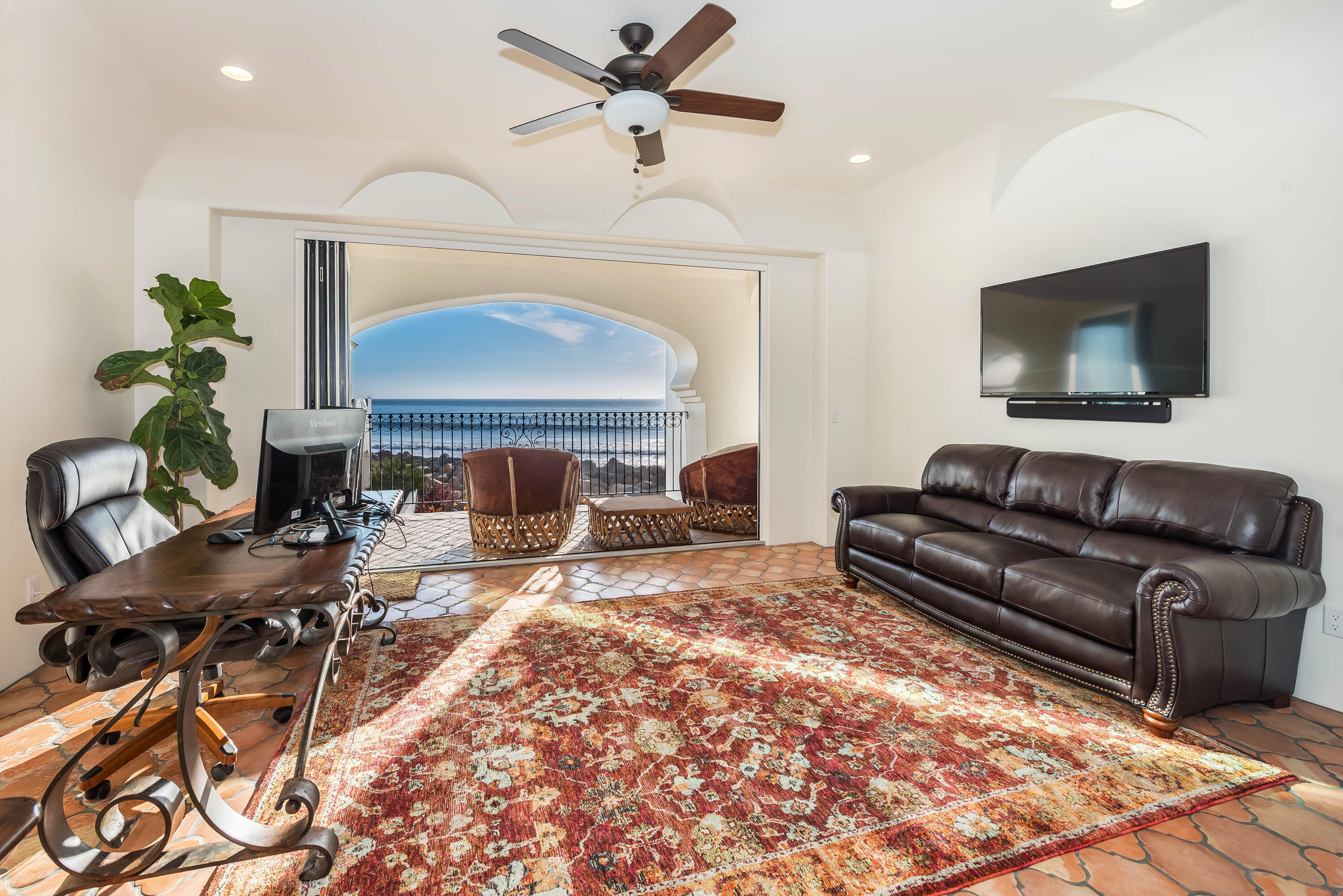 875 Sand Point Road Carpinteria, CA 93013 - Photo 10 of 25 a living room with furniture a fireplace and a flat screen tv