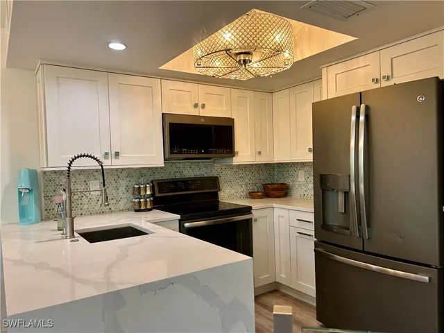 a kitchen with stainless steel appliances a stove refrigerator sink and microwave