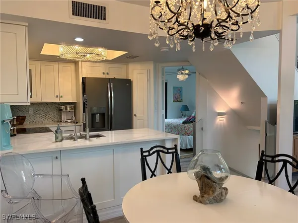 a kitchen with a table chairs and a refrigerator