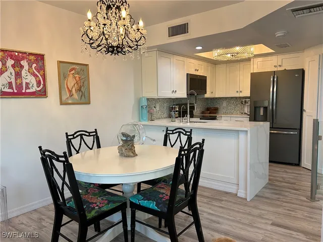 a view of a dining room with furniture wooden floor and a chandelier