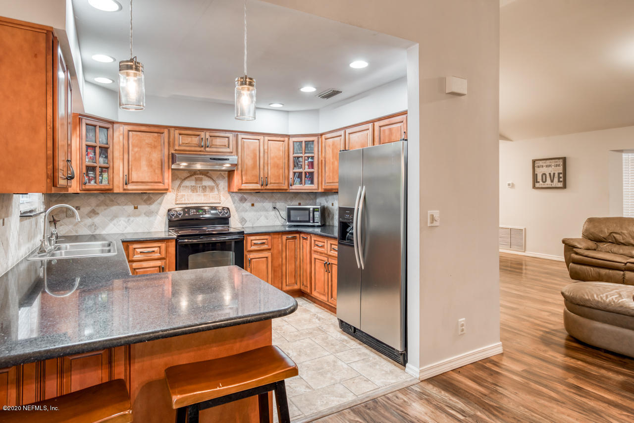 332 Shamrock Road St. Augustine, FL 32086 - Photo 11 of 26 a kitchen with stainless steel appliances granite countertop a sink a stove and a refrigerator
