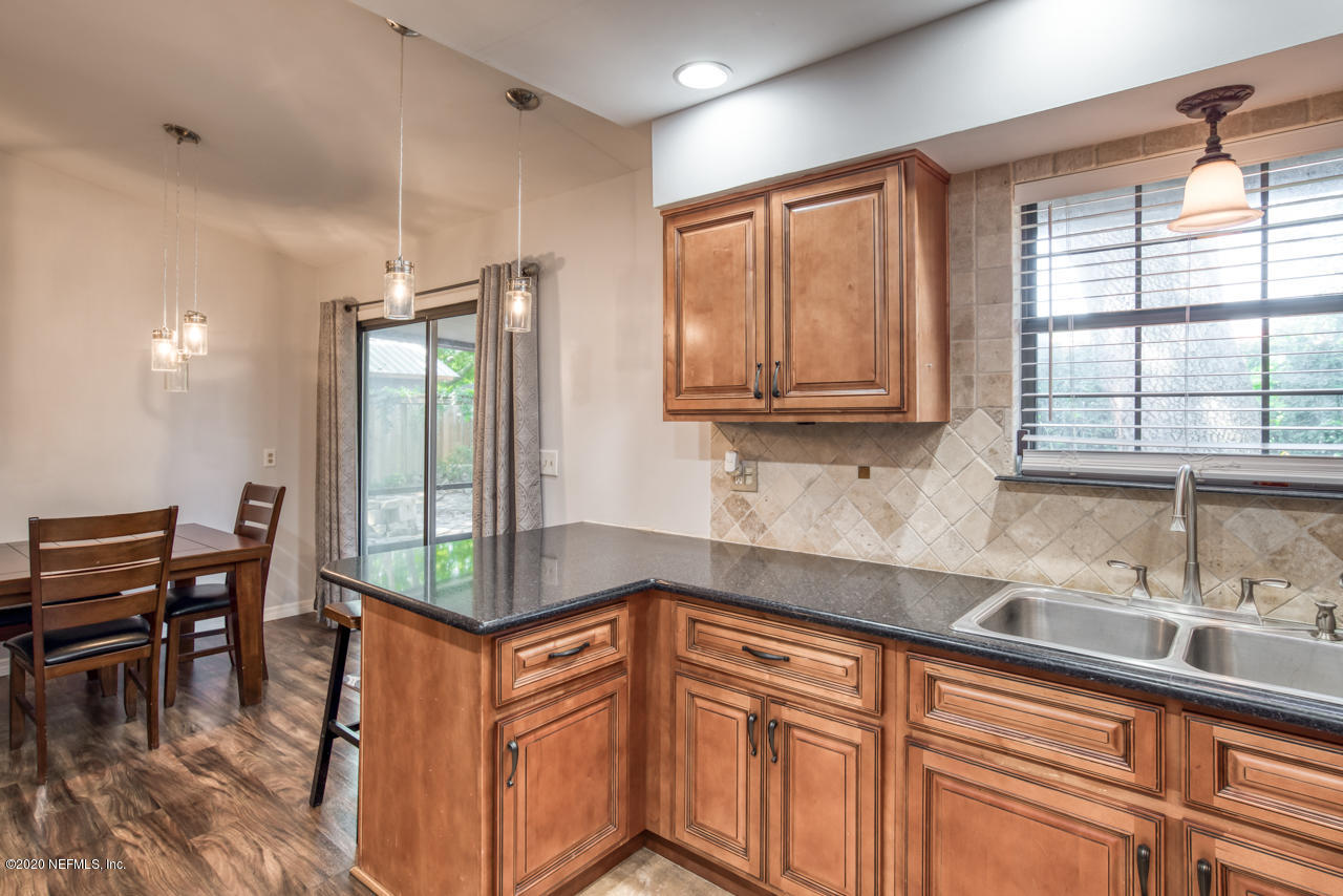 332 Shamrock Road St. Augustine, FL 32086 - Photo 12 of 26 a kitchen with stainless steel appliances granite countertop a stove a sink and a microwave