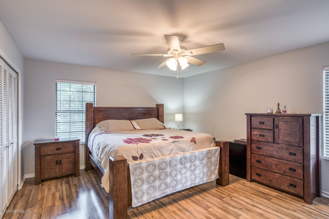 332 Shamrock Road St. Augustine, FL 32086 - Photo 13 of 26 a bedroom with a bed and a chandelier