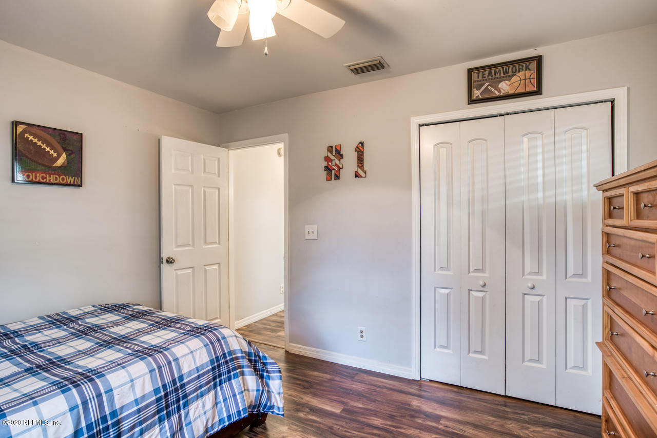 332 Shamrock Road St. Augustine, FL 32086 - Photo 17 of 26 a bedroom with a bed and a chandelier