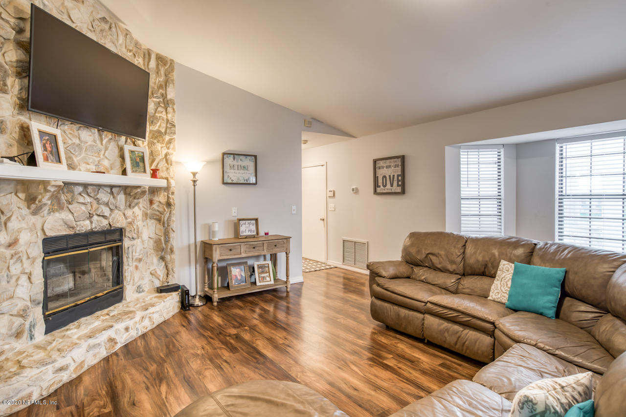 332 Shamrock Road St. Augustine, FL 32086 - Photo 5 of 26 a living room with furniture a flat screen tv and a fireplace