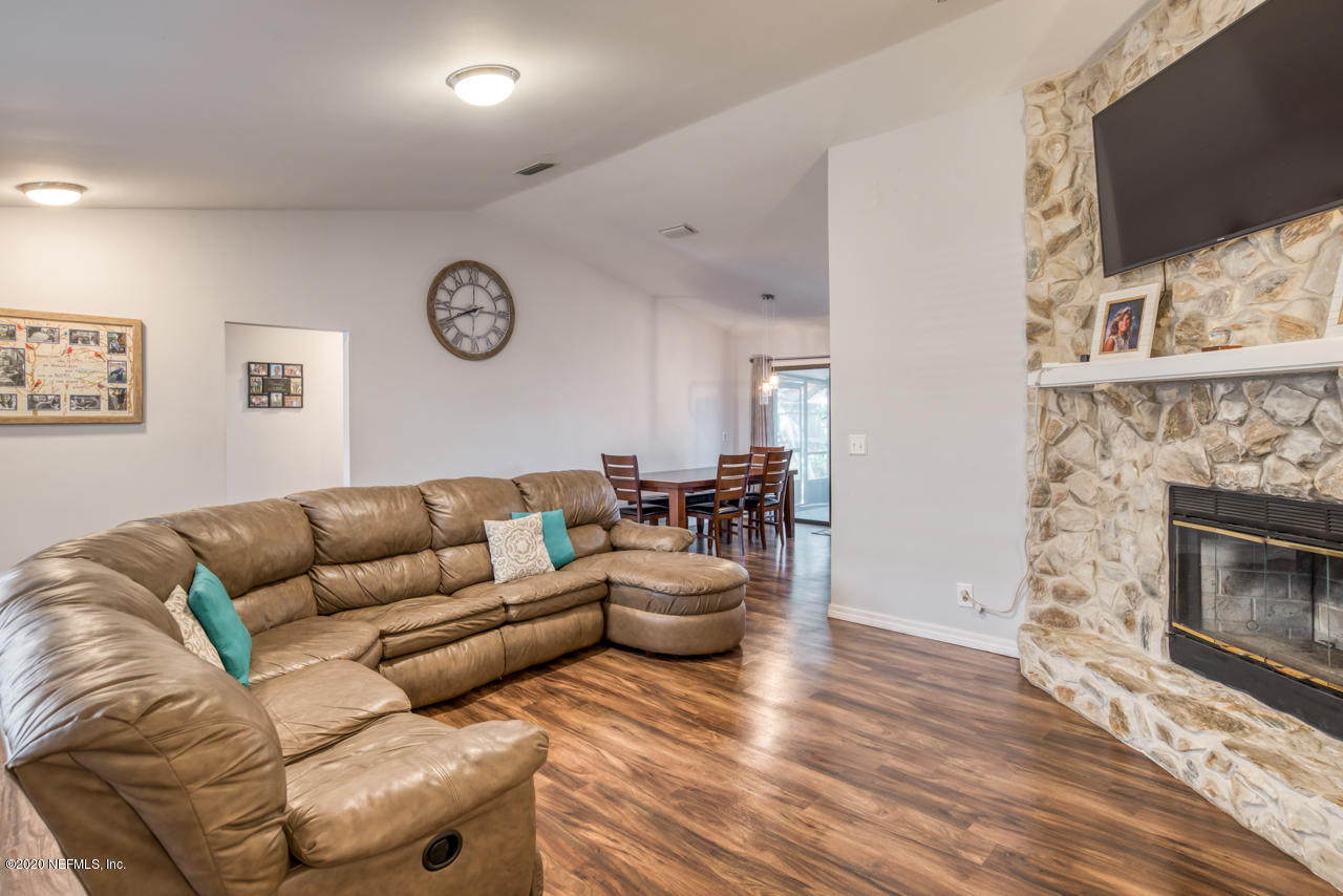 332 Shamrock Road St. Augustine, FL 32086 - Photo 7 of 26 a living room with furniture a fireplace and a flat screen tv