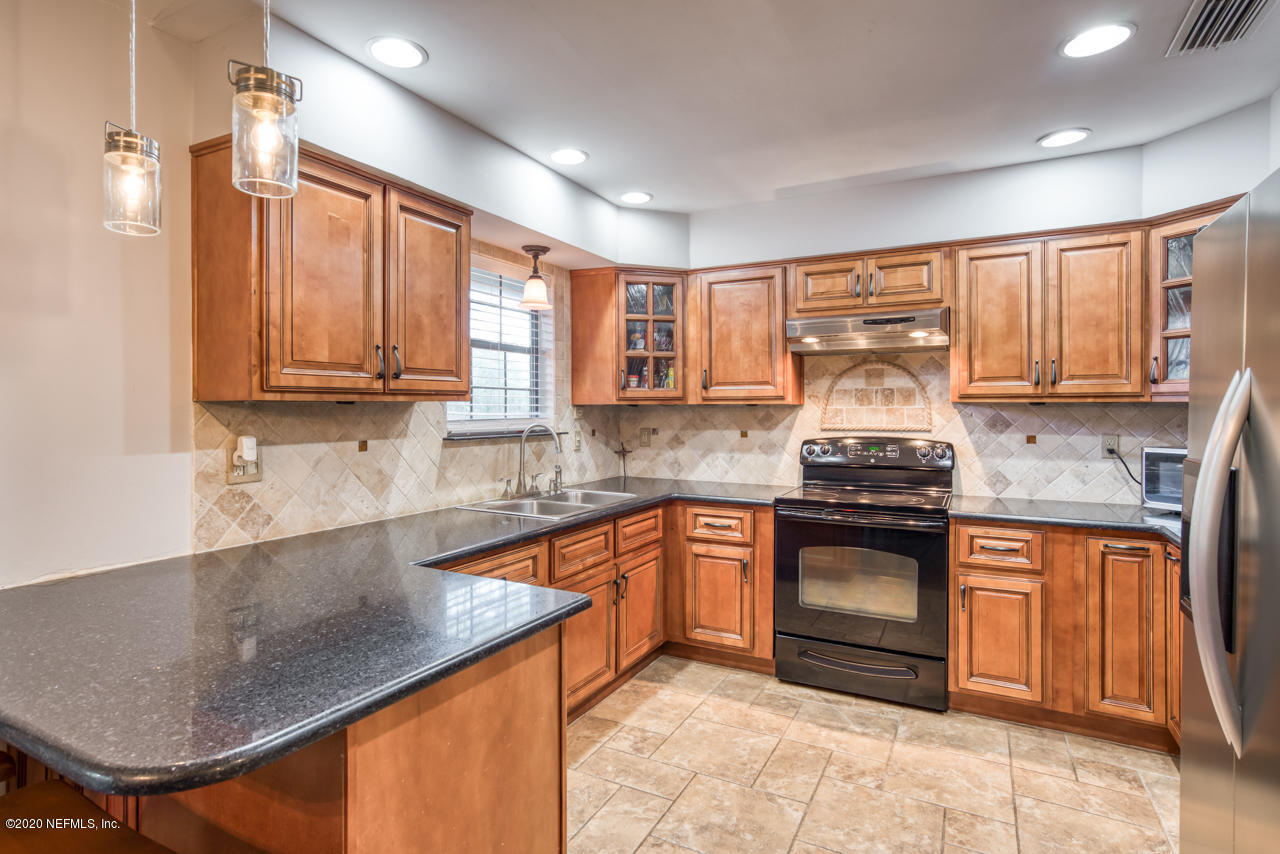 332 Shamrock Road St. Augustine, FL 32086 - Photo 10 of 26 a kitchen with stainless steel appliances granite countertop a stove sink and cabinets