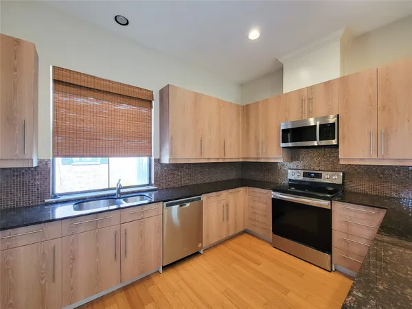 a kitchen with stainless steel appliances granite countertop a sink and a stove