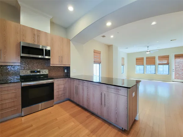 a kitchen with stainless steel appliances granite countertop a stove a sink and a microwave