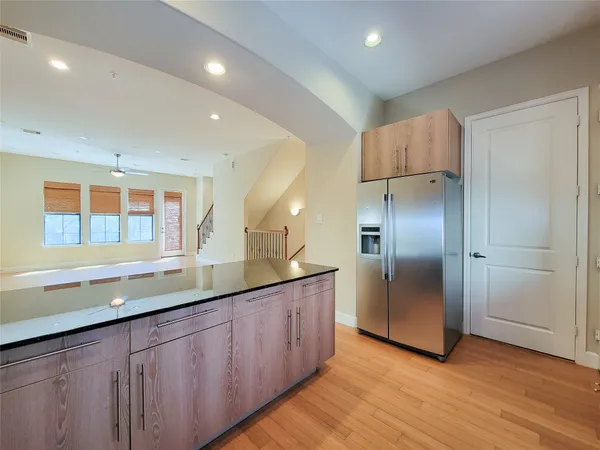 a kitchen with stainless steel appliances granite countertop a sink and a large mirror refrigerator