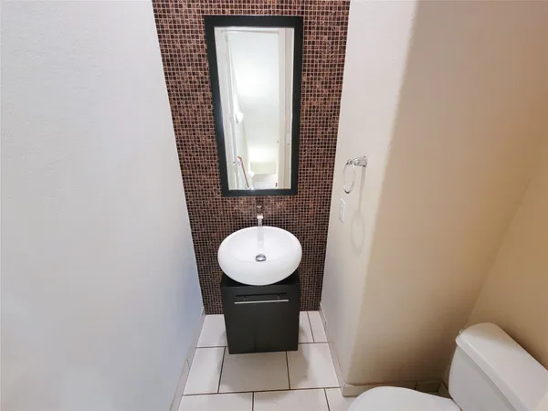 a bathroom with a toilet mirror and vanity