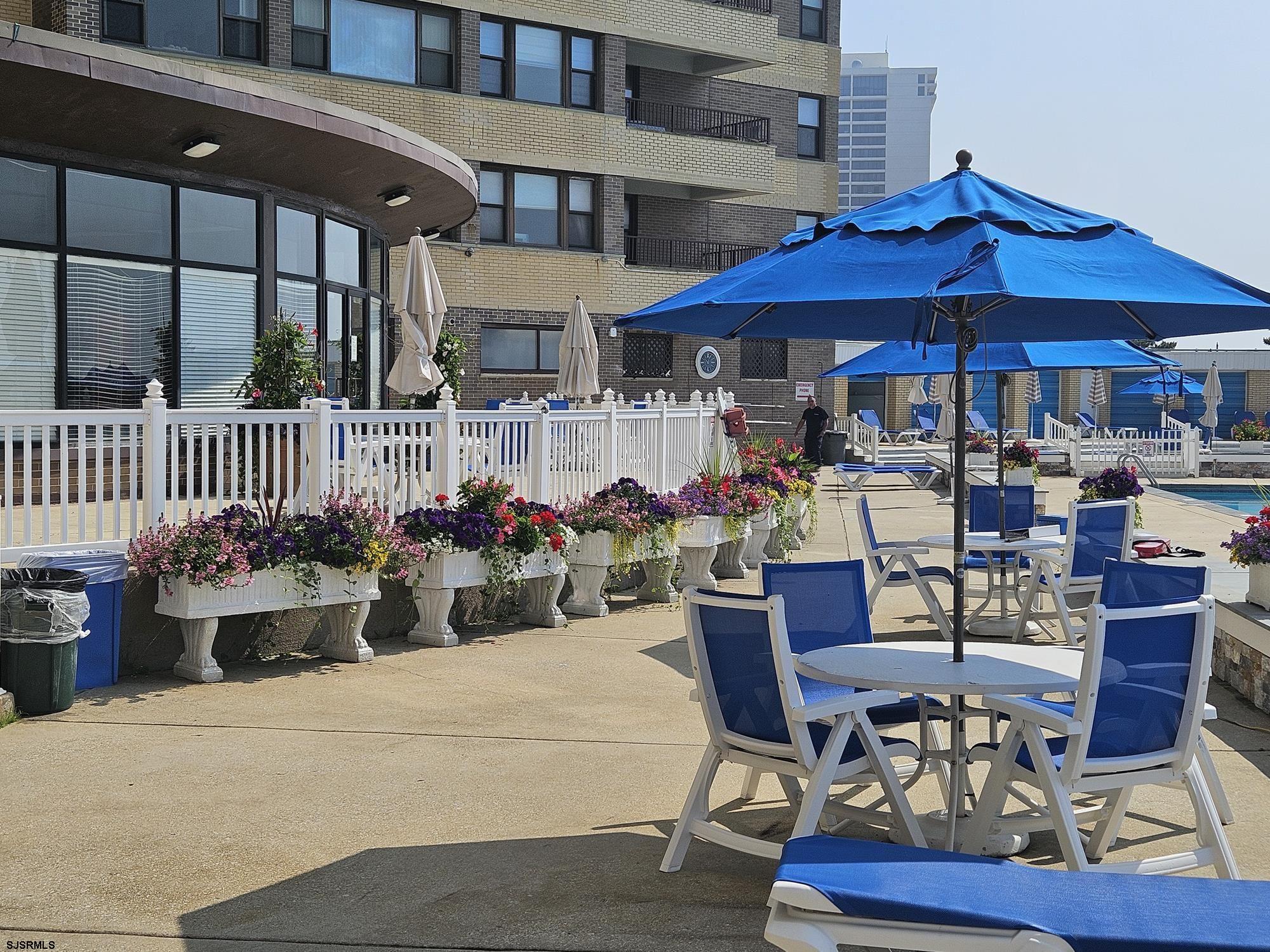 101 South Raleigh Avenue, Unit 734 Atlantic City, NJ 08401 - Photo 21 of 32 a view of a patio with a dining table and chairs under an umbrella
