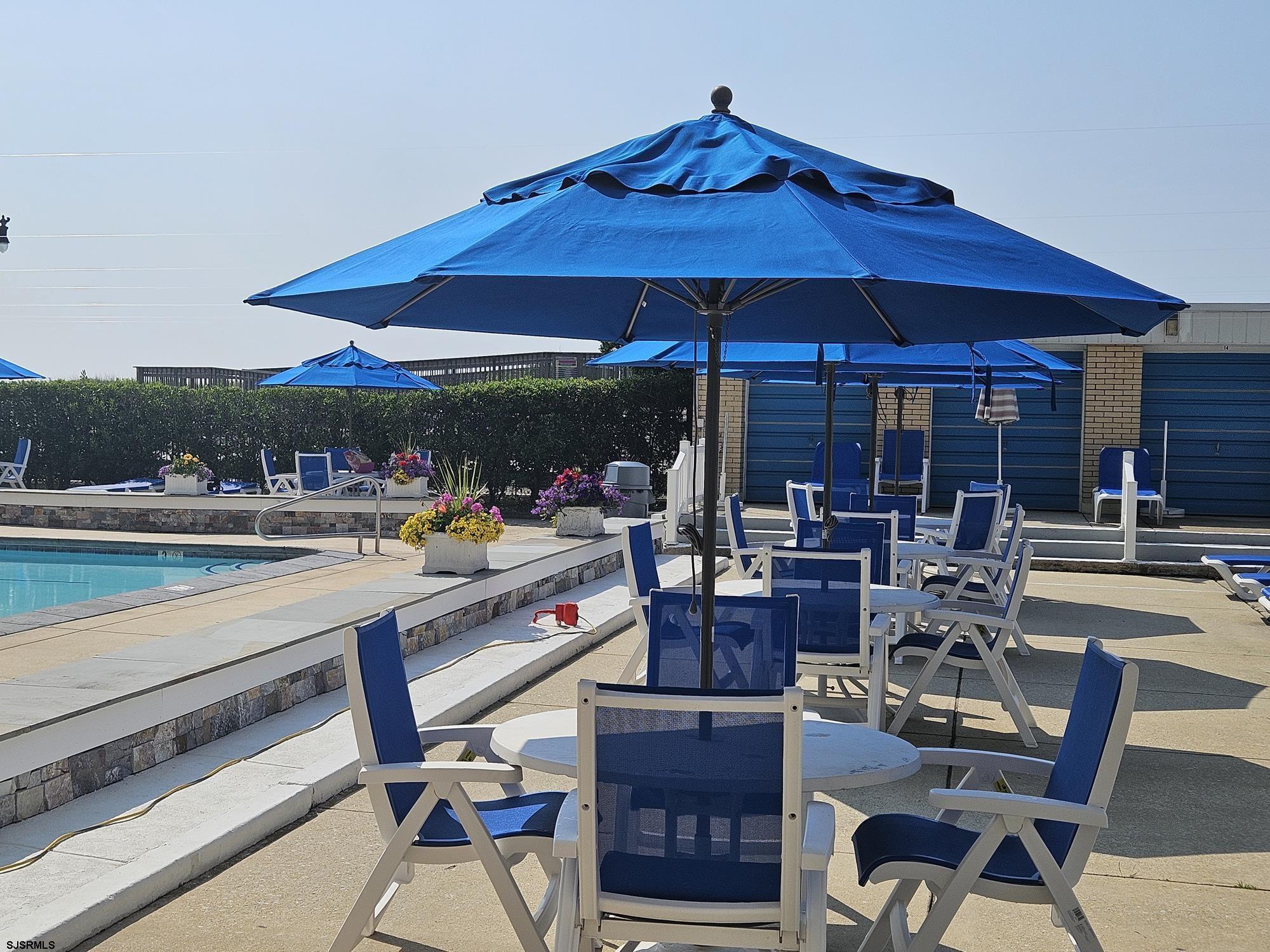 101 South Raleigh Avenue, Unit 734 Atlantic City, NJ 08401 - Photo 22 of 32 a patio with a table and chairs under an umbrella