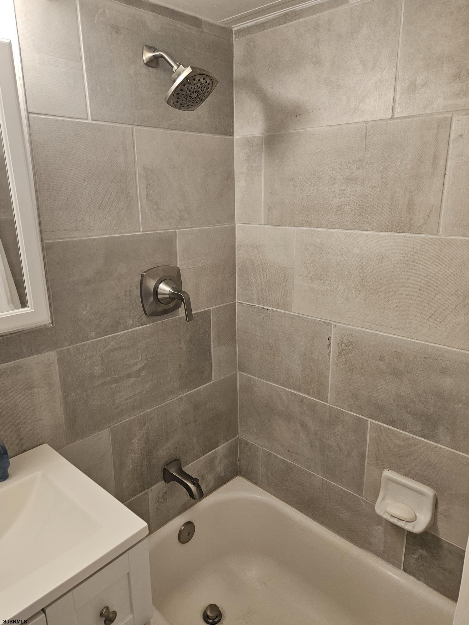 101 South Raleigh Avenue, Unit 734 Atlantic City, NJ 08401 - Photo 10 of 32 a bath tub sitting next to a white sink and a shower