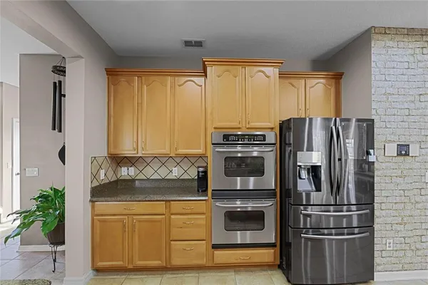 a kitchen with stainless steel appliances granite countertop a refrigerator sink and stove