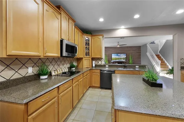 a kitchen with stainless steel appliances granite countertop a sink a stove top oven a counter space and cabinets