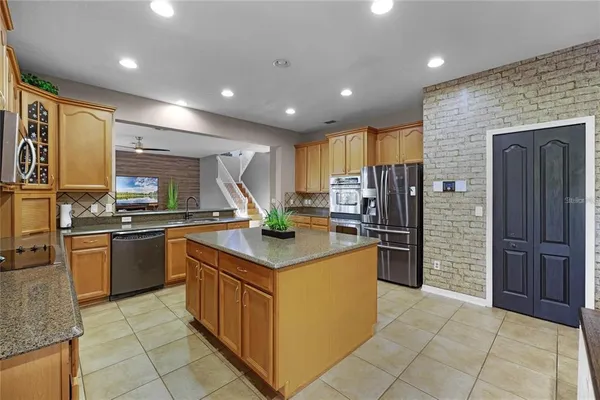 a kitchen with stainless steel appliances granite countertop a stove refrigerator and cabinets