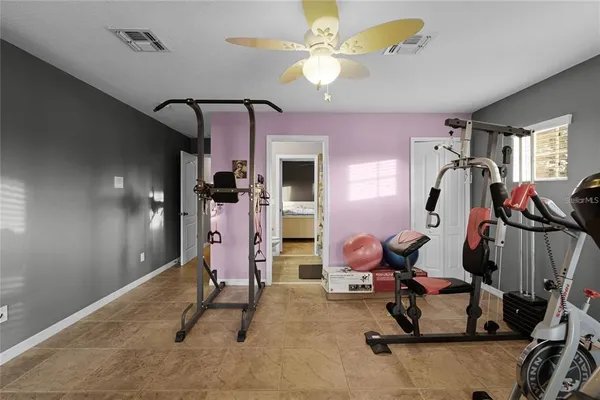 a room with gym equipment and a chandelier