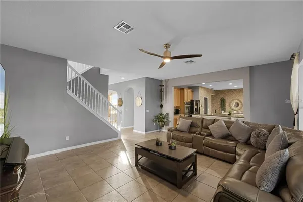 a living room with furniture and a ceiling fan