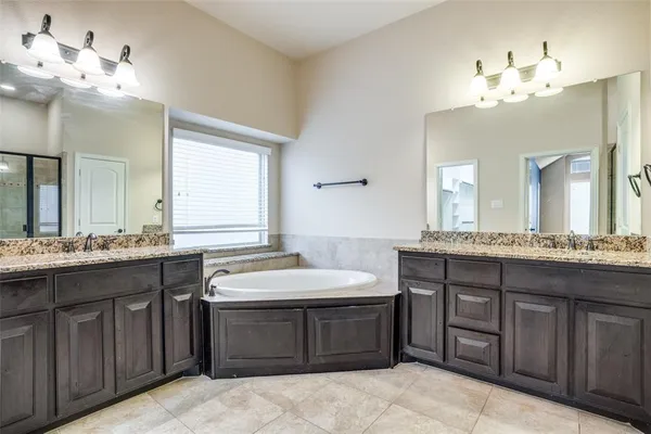 a bathroom with a granite countertop double vanity sink large mirror and granite