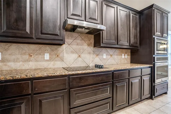 a kitchen with granite countertop cabinets and black stainless steel appliances