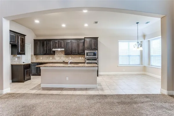 a large kitchen with kitchen island granite countertop a large counter top stainless steel appliances and cabinets