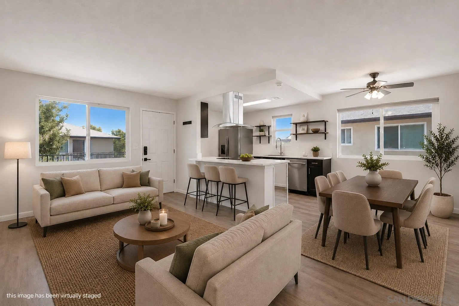 a living room with furniture and a dining table with kitchen view