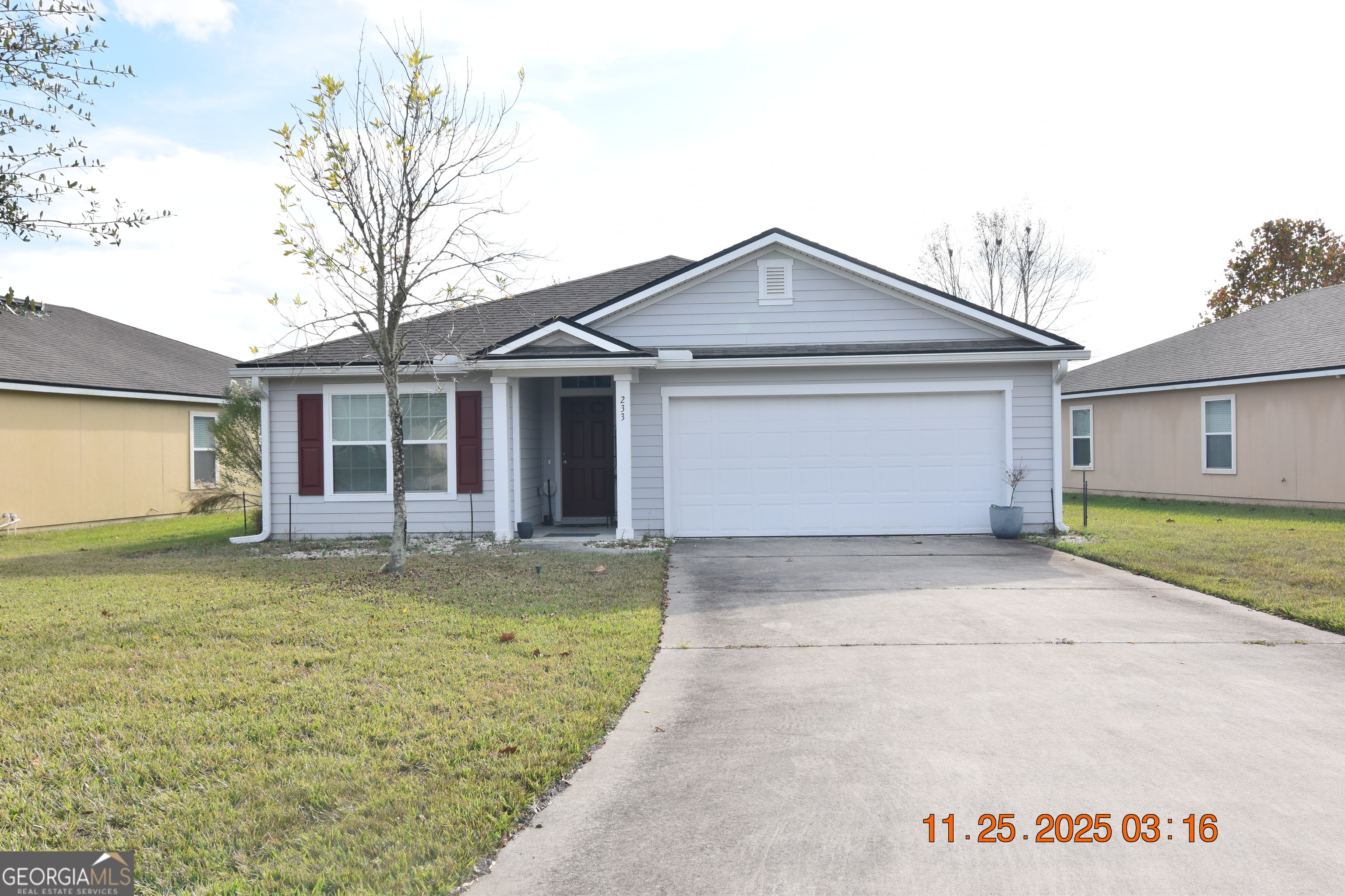 a front view of a house with a garden and yard