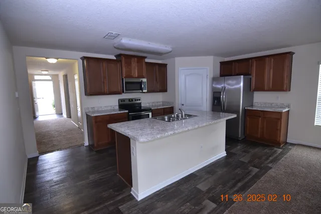 a kitchen with stainless steel appliances granite countertop a sink stove and refrigerator
