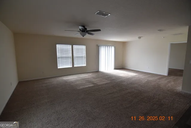 a view of a livingroom with a ceiling fan and window