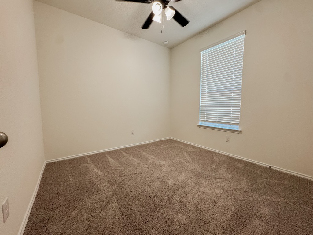 4024 Pinto Lane Round Rock, TX 78665 - Photo 19 of 31 an empty room with a chandelier fan and windows