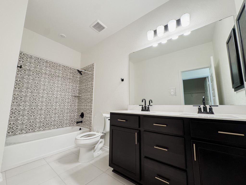 4024 Pinto Lane Round Rock, TX 78665 - Photo 22 of 31 a bathroom with a double vanity sink toilet mirror and bathtub
