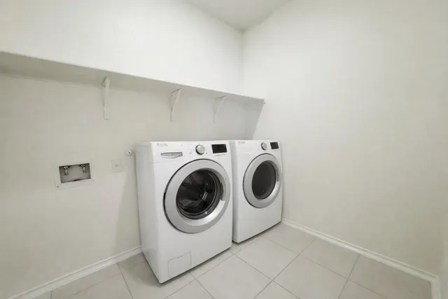 a view of a large pool with lawn chairs under an umbrella
