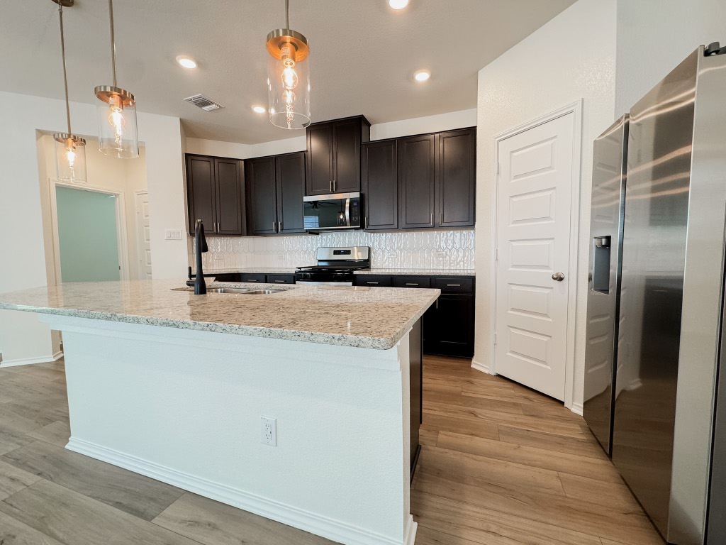 4024 Pinto Lane Round Rock, TX 78665 - Photo 3 of 31 a kitchen with kitchen island a sink stainless steel appliances and cabinets