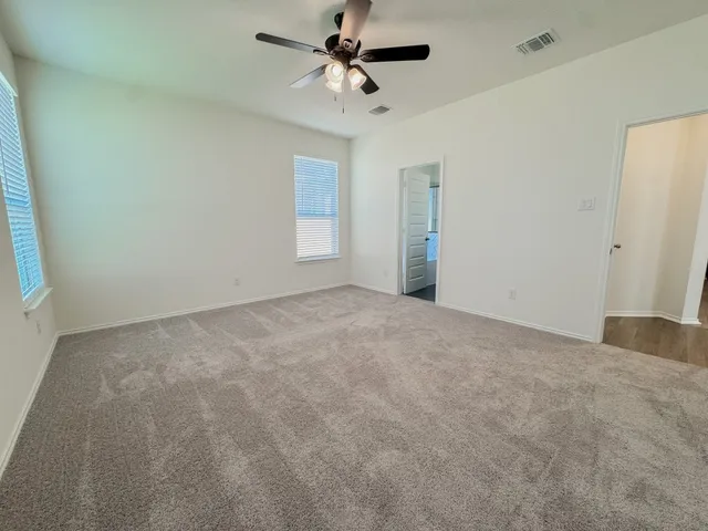 a view of a room with a ceiling fan and window