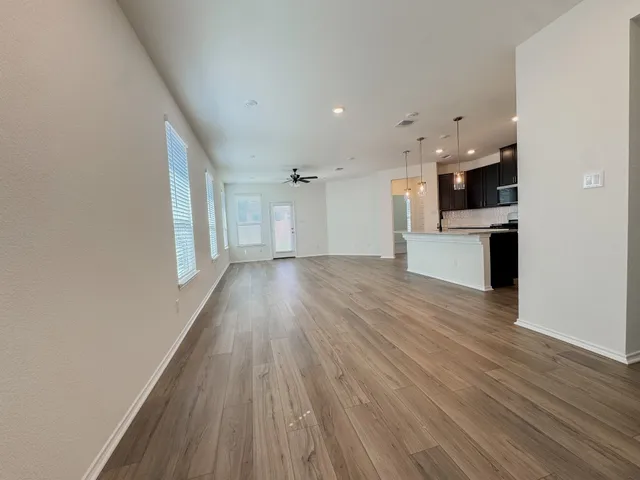 a view of a kitchen with a stove cabinets wooden floor and a ceiling fan