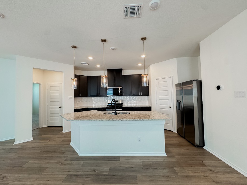 4024 Pinto Lane Round Rock, TX 78665 - Photo 10 of 31 a large kitchen with stainless steel appliances granite countertop a stove top oven a refrigerator and a sink