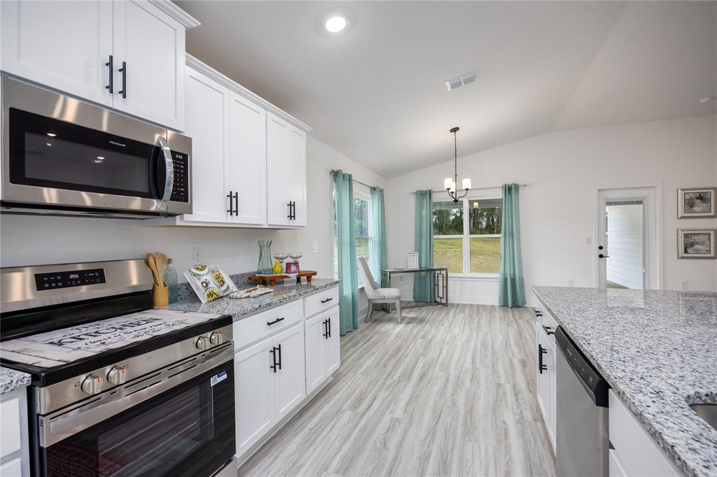 16929 Northwest 176th Way Alachua, FL 32615 - Photo 13 of 35 a kitchen with stainless steel appliances granite countertop a stove and a microwave