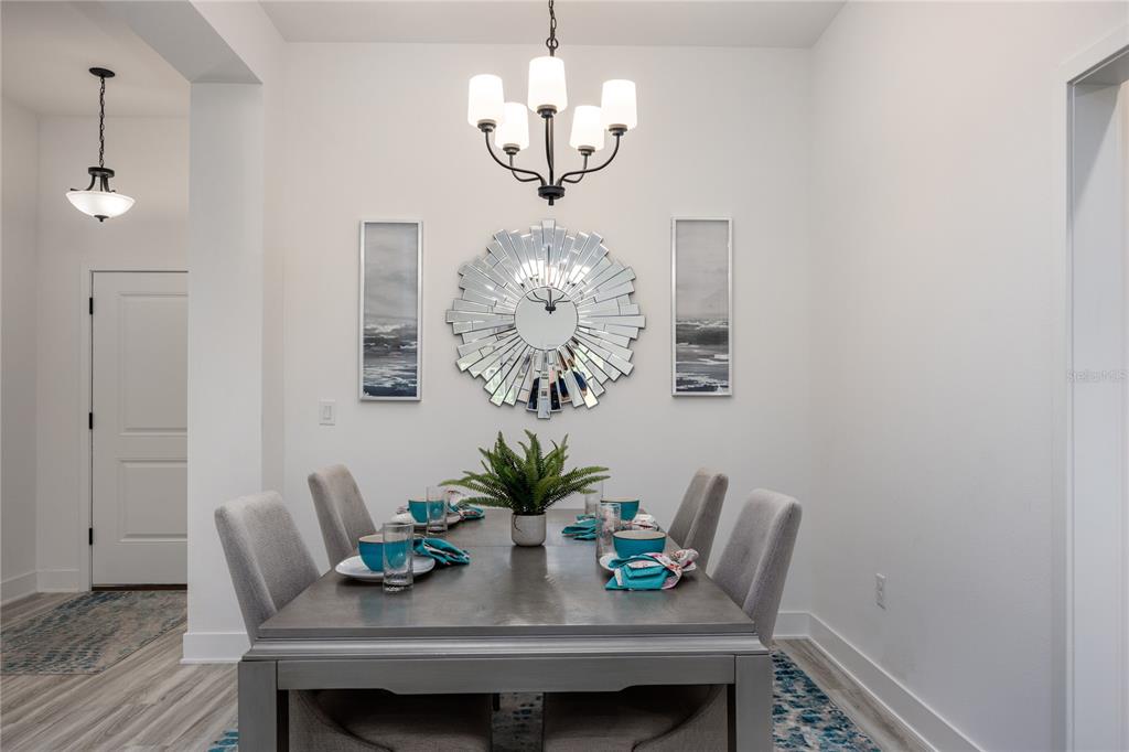 16929 Northwest 176th Way Alachua, FL 32615 - Photo 4 of 35 a dining room with furniture a chandelier and wooden floor