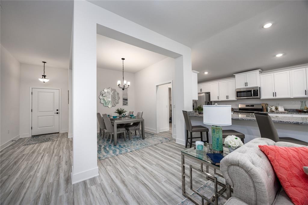 16929 Northwest 176th Way Alachua, FL 32615 - Photo 5 of 35 a kitchen with granite countertop stainless steel appliances refrigerator dining table and chairs