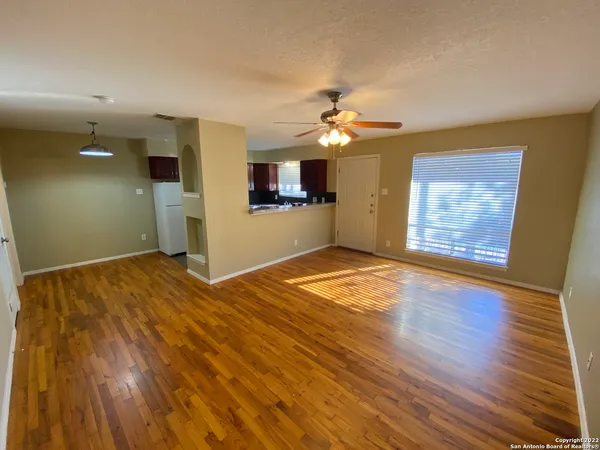 a view of a room with wooden floor and ceiling fan