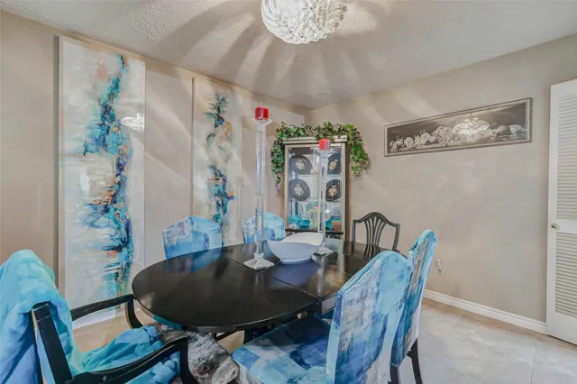 a dining room with furniture a chandelier and wooden floor