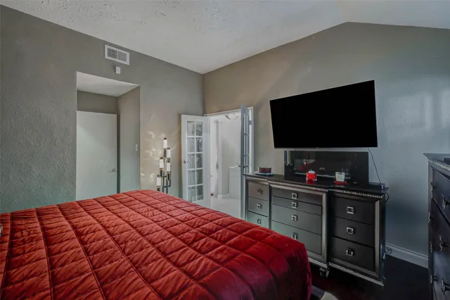 a bedroom with a bed and a flat screen tv