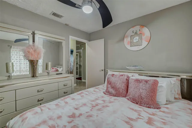 a bedroom with a large bed and a chandelier