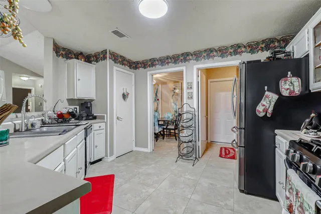 a kitchen with refrigerator and cabinets
