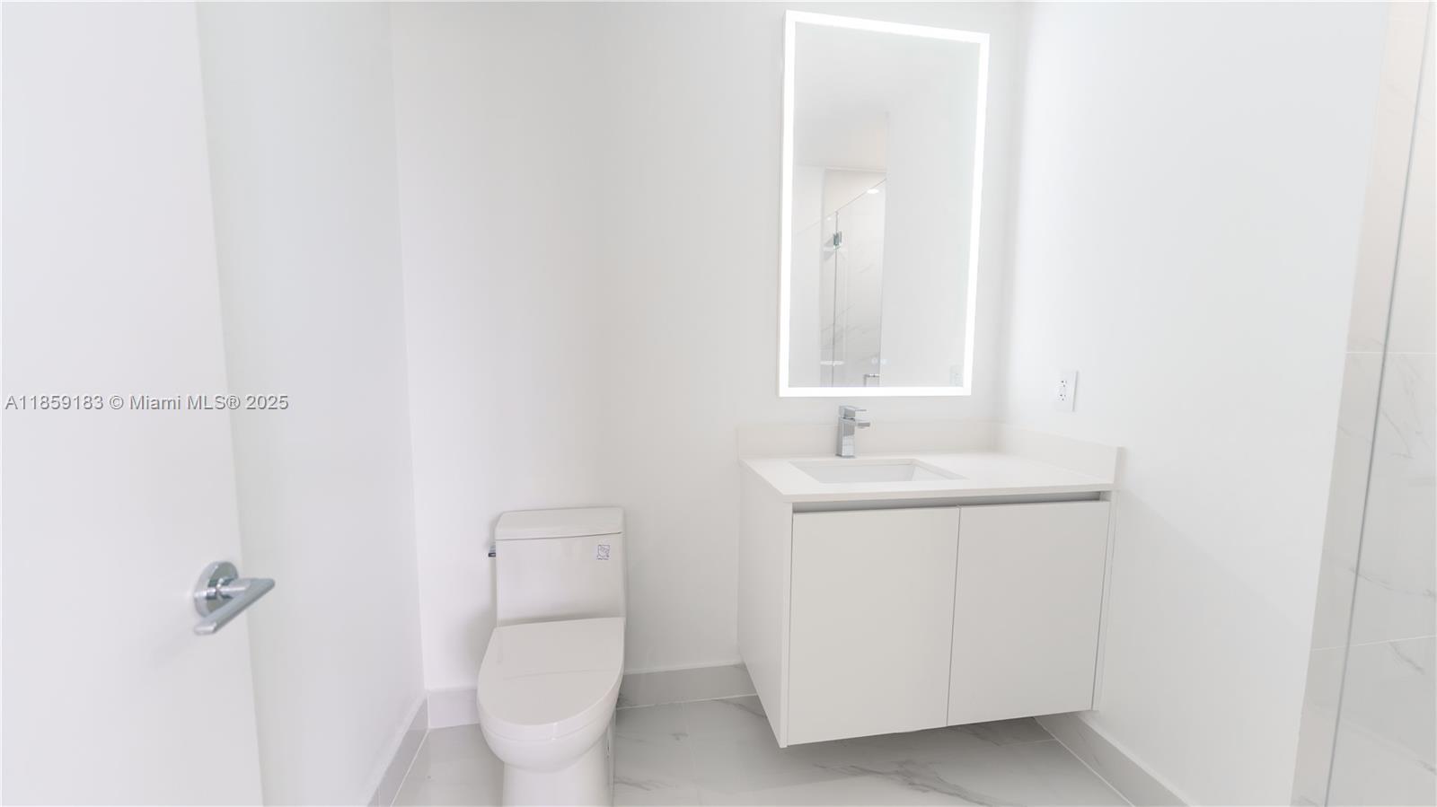 700 Northeast 24th Street, Unit 2905 Miami, FL 33137 - Photo 22 of 36 a bathroom with a sink a toilet and a mirror