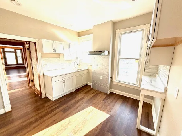a view of a room with wooden floor and furniture