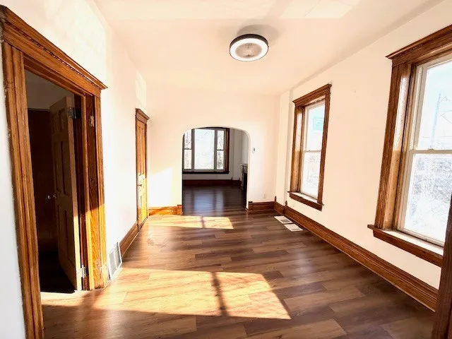 a view of a living room with a fireplace and wooden floor