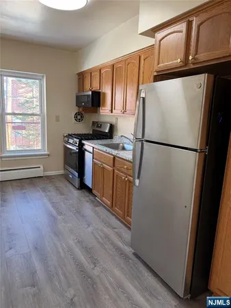 a kitchen with granite countertop stainless steel appliances a refrigerator a stove a microwave and cabinets