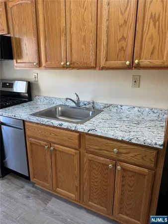 a kitchen with granite countertop a sink and cabinets